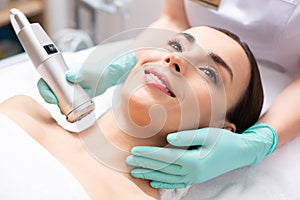 Face of smiling lady having oxygen meso therapy tool near her neck photo