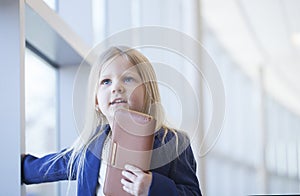 Face of smiling little girl wearing blue jacket holding wallet