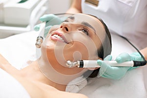 Face of smiling woman with metal prongs on her cheeks