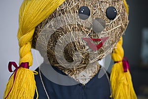 Face of a straw doll in ethnic folk style with yellow braids