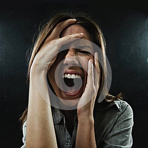 Face, stress and horror with woman screaming in studio on black background for reaction to fear. Phobia, anxiety and