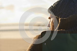 Face, thinking and man at beach at sunset to relax on holiday or vacation for travel in summer. Nature, sunshine and