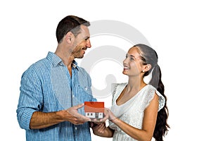 Face to face couple holding house model