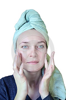 Face treatment. Portrait of beautiful woman with towel on her head use face cream cosmetics on her face.