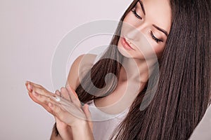 Face Treatment. Woman in Beauty Salon. Applying cosmetic cream. A beautiful young woman applying face moisturizer. Scine care of t