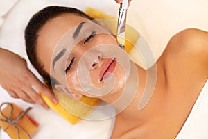 Face Treatment. Woman in Beauty Salon Gets Marine Mask