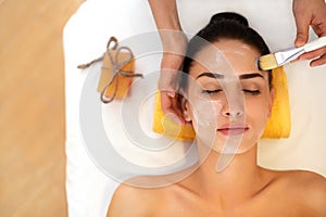 Face Treatment. Woman in Beauty Salon Gets Marine Mask