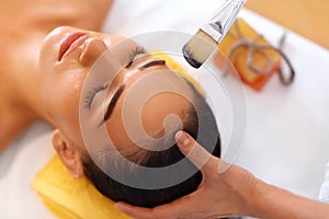 Face Treatment. Woman in Beauty Salon Gets Marine Mask