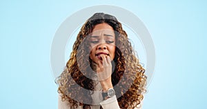 Face, woman and biting nails with stress, anxiety and depression on a blue studio background. Portrait, person and model