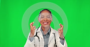 Face, woman and doctor with fingers crossed, green screen and hope with healthcare, happiness and luck. Portrait, female