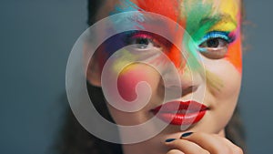 Face, woman and rainbow paint makeup, creative art and fantasy cosmetics on studio background. Portrait girl, splash of