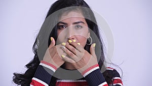 Face of young beautiful Persian woman showing speak no evil concept