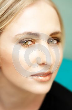Face of young blond woman with green eyes