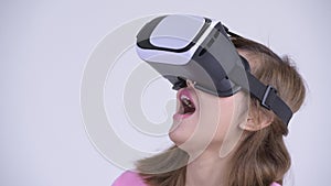 Face of young happy Asian woman looking surprised while using virtual reality headset