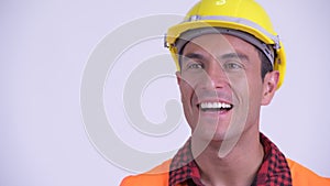 Face of young happy Hispanic man construction worker thinking