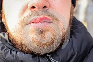 Face of a young man with messy and untrimmed beard and moustache close-up. Selective focus photo