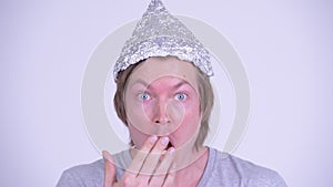 Face of young man with tinfoil hat looking shocked