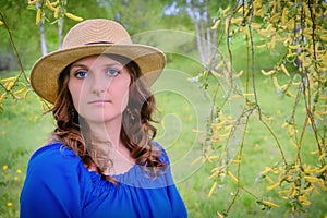 Face young woman in a blue dress on a willow background