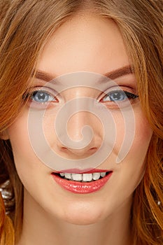 Face of young woman with blue eyes and red lips. Beauty portrait, fresh skin. Natural makeup