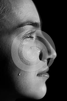 Face of young woman with tear drop close up