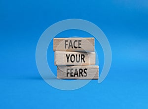 Face your Fears symbol. Wooden blocks with words Face your Fears. Beautiful blue background. Business and Face your Fears. Copy