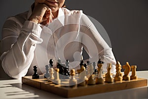 Faceless caucasian woman in white shirt playing chess.