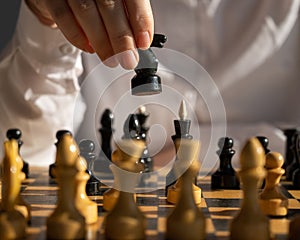 Faceless caucasian woman in white shirt playing chess.