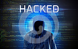 Faceless hacker on code background