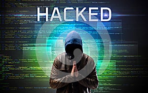 Faceless hacker on code background