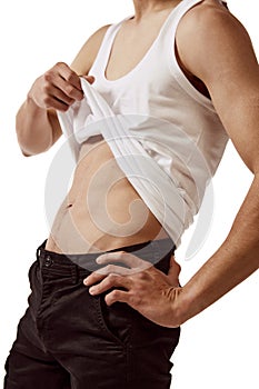 Faceless image of young male body, man showing belly muscles isolated over white background. Fitness care. Concept of