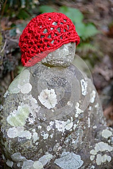 Faceless Jizo Bosatsu statue wearing red cap