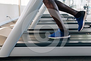 Faceless male runner running on treadmill