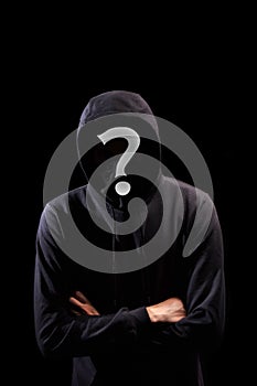 Faceless man in hoodie with question mark standing  on black
