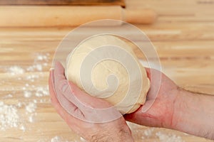 Faceless man kneading dough on kitchen table at home, apartment, flour, scales
