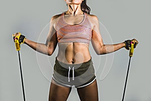 Faceless portrait of young fit and athletic sport woman working hard with elastic resistance bands in fitness workout training iso