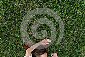 Faceless shot of woman lying on green grass