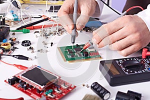 Faceless technician repairing smartphone`s motherboard in lab, radioman soldering spare part of computer. Concept of computer