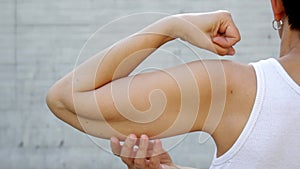 A faceless  woman shows the flabby muscles of the arm