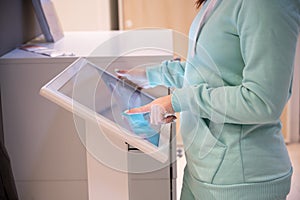 Faceless woman touching the screen of a self-service device in a store. Device store navigator. Self purchase.