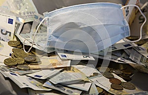 Facemask on a jar of euro coins