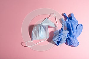 Facemask and nitrile gloves waste over pink