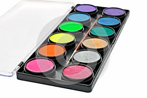 Facepaint palette and brush over white background