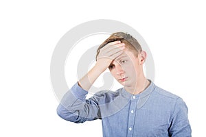 Facepalm embarrassment and shame emotion. Ashamed teen boy covering his forehead with a hand. Desperate young lad portrait