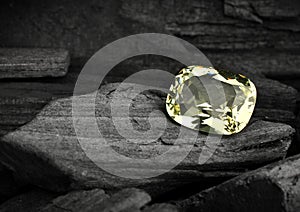 Faceted yellow jewelry gemstone on darck background photo