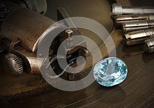 Faceting gemston, big diamond with jewelery equipment on background. Jewellery manufacture. photo