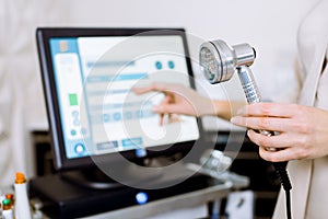 Facial Beauty Treatment. Cropped image of hand of professional woman cosmeolotgist holding a tool for Led Light Therapy