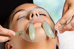 Facial beauty treatment with jade rollers.