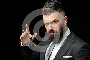 Facial care. bearded man in formal business suit. brutal male hipster cut hair with hairdressing scissors. confident