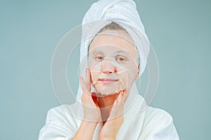 Facial care and beauty treatments. Beautiful woman with a sheet moisturizing mask on her face