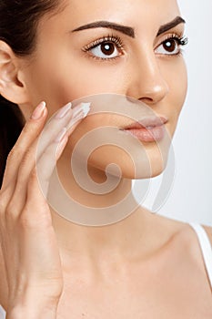 Facial Care. Female Applying Cream.Portrait Of  Young Woman With Cosmetic Cream On Skin. Closeup Of Beautiful Girl With Beauty